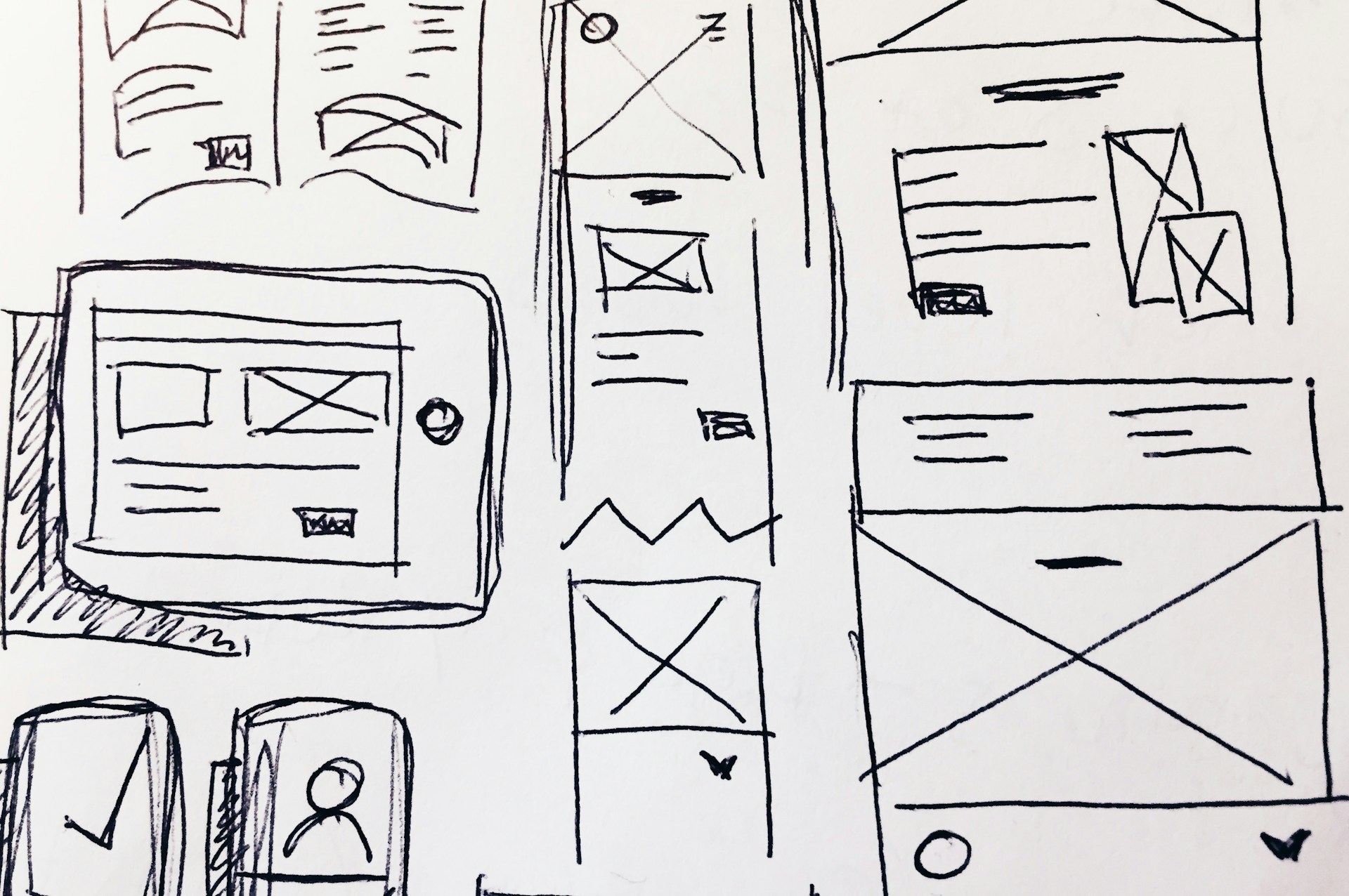 Hand-drawn website wireframes on paper